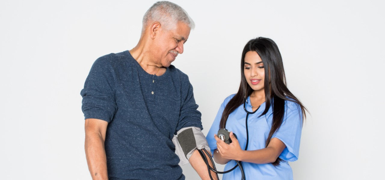 Caregiver taking patient's blood pressure